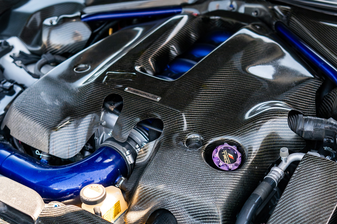Carbon engine cover detail on Dana Balthasar’s Lexus RC F with blue engine bay accents.
