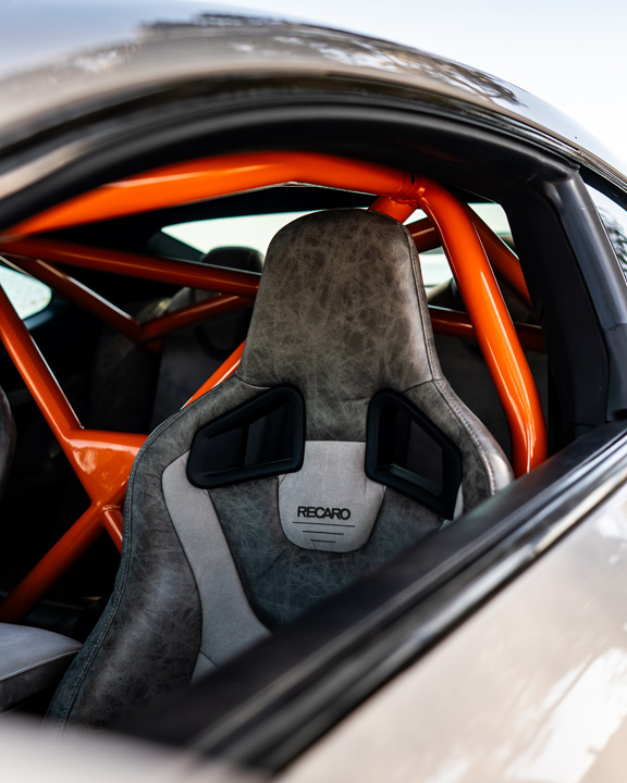 Interior detail of Dana Balthasar’s Lexus RC F showing Recaro Sportster GT seats and orange roll cage.