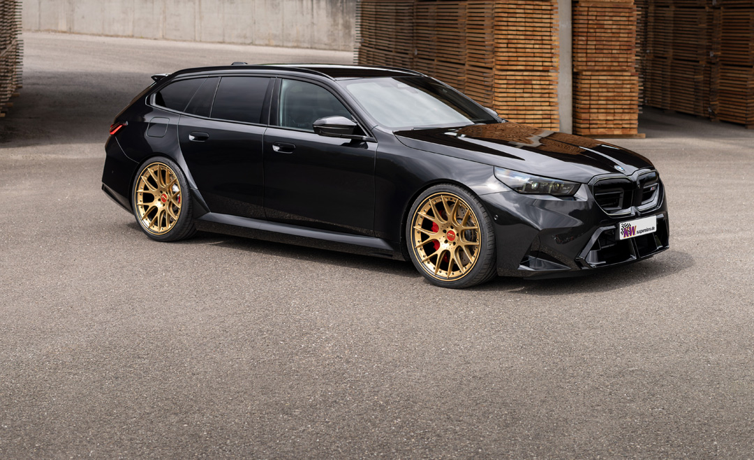 BMW M5 Touring G99 lowered on KW height-adjustable springs with gold wheels, shown from a front three-quarter side angle.