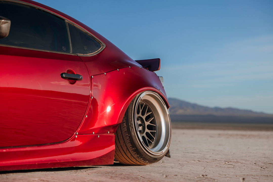 Rear widebody and wheel detail of Anthony Gonzales’ red Scion FR-S parked in the desert.