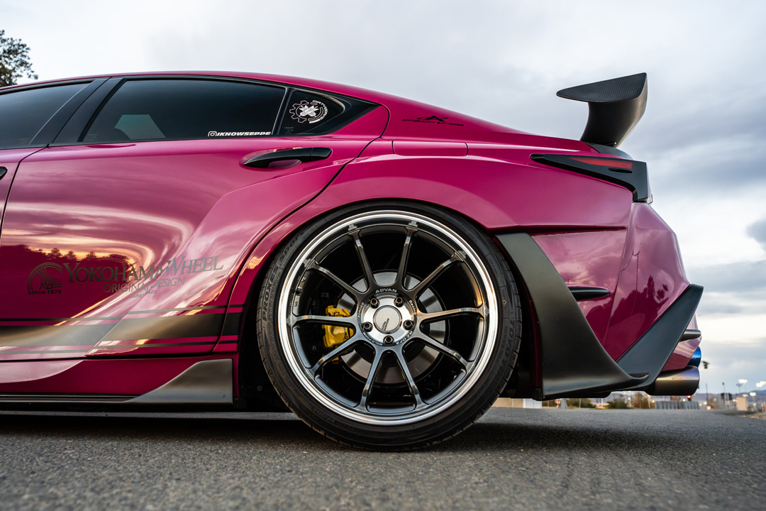 Rear quarter detail of Giuseppe Balthasar’s pink widebody Lexus IS 500 showing the rear wheel, wing, and Artisan Spirits bodywork.
