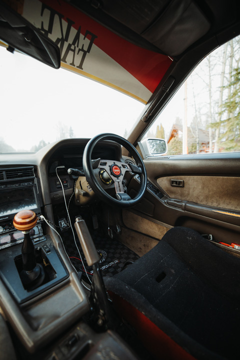 Interior of Gary Zackodnik’s Toyota Soarer showing the OBA steering wheel, manual shifter, and Kaido racer-inspired cabin details.