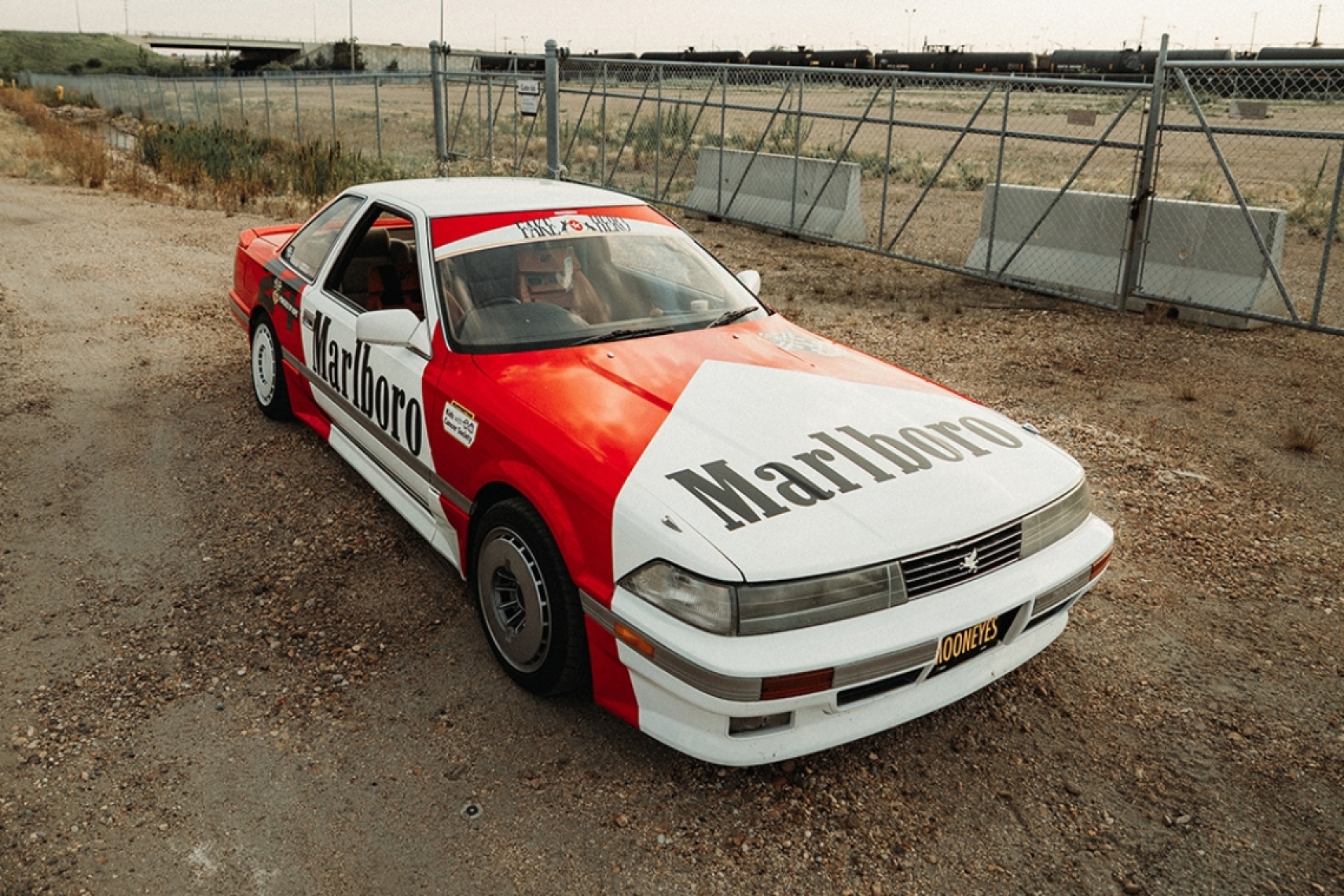 Gary Zackodnik’s 1988 Toyota Soarer with Marlboro-inspired livery parked near train tracks.