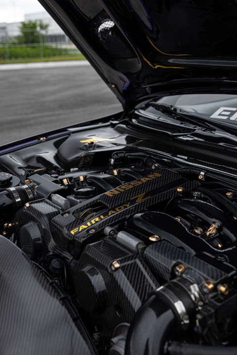 Engine bay detail of Alex Hammond’s 1993 Nissan 300ZX Convertible showing carbon-fiber engine covers, gold hardware, and detailed presentation work.