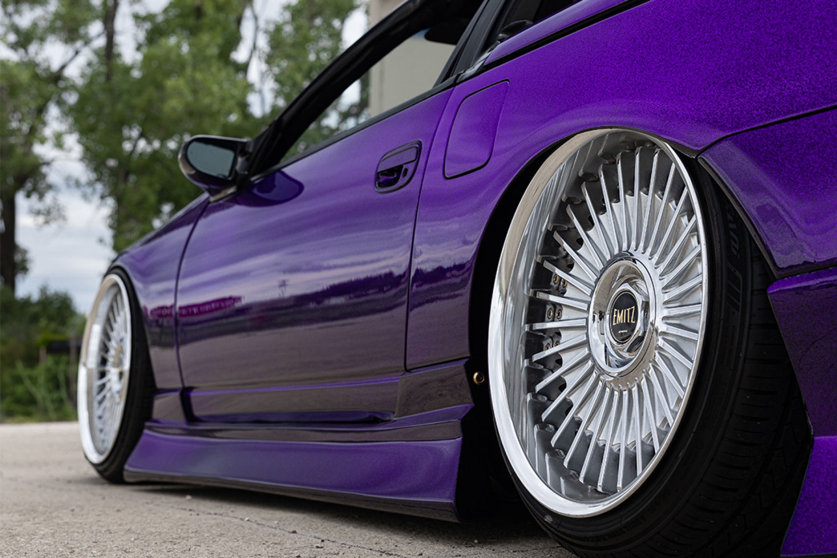 Close-up of Alex Hammond’s purple 1993 Nissan 300ZX Convertible showing the low stance, polished wheels, side skirt, and custom paint.