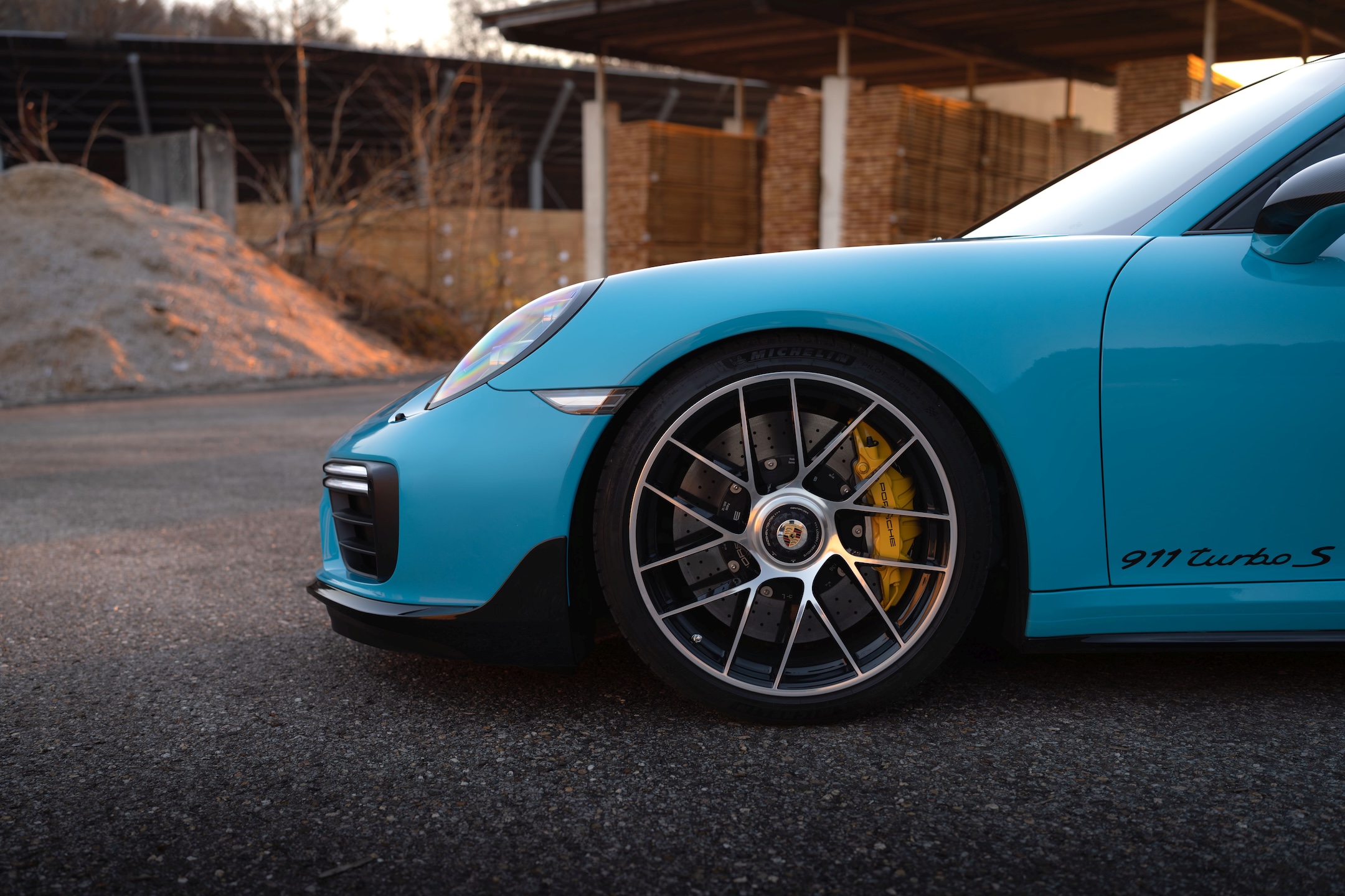 Close-up of a blue Porsche 911 Turbo S 991 front wheel and fender showing the lowered stance with KW DDC Plug & Play coilovers.