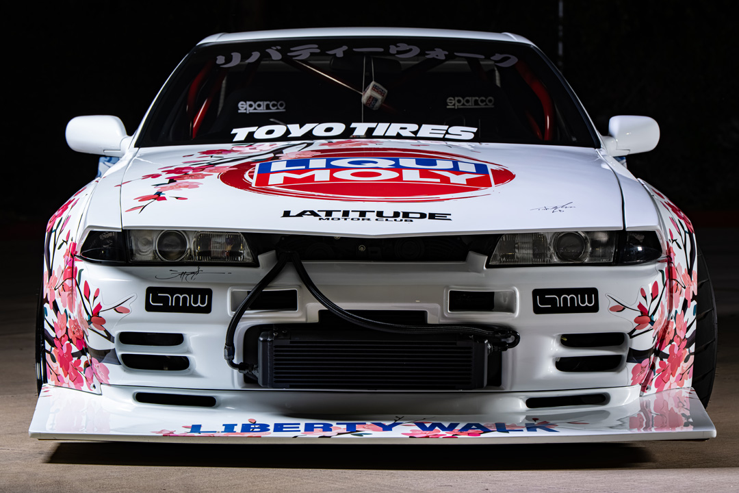 Osmond Seangsuwan’s 1990 Nissan Skyline GT-R with Liberty Walk LB-Kaido widebody aero, LIQUI MOLY livery, Rohana wheels, Toyo tires, RB26 power, carbon interior, and Japanese-inspired artwork.