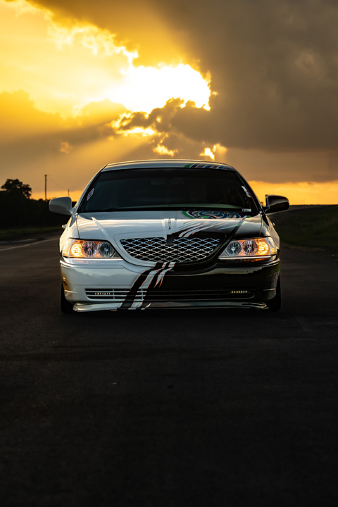 Sam Benischek’s 2006 Lincoln Town Car Signature Limited with custom Two-Face graphic paint, low air suspension stance, KRNC forged wheels, custom interior, trunk setup, and full-size luxury sedan styling.