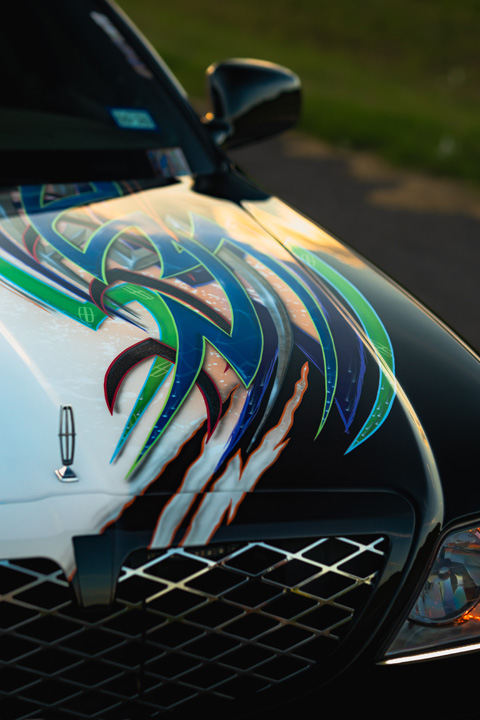 Sam Benischek’s 2006 Lincoln Town Car Signature Limited with custom Two-Face graphic paint, low air suspension stance, KRNC forged wheels, custom interior, trunk setup, and full-size luxury sedan styling.
