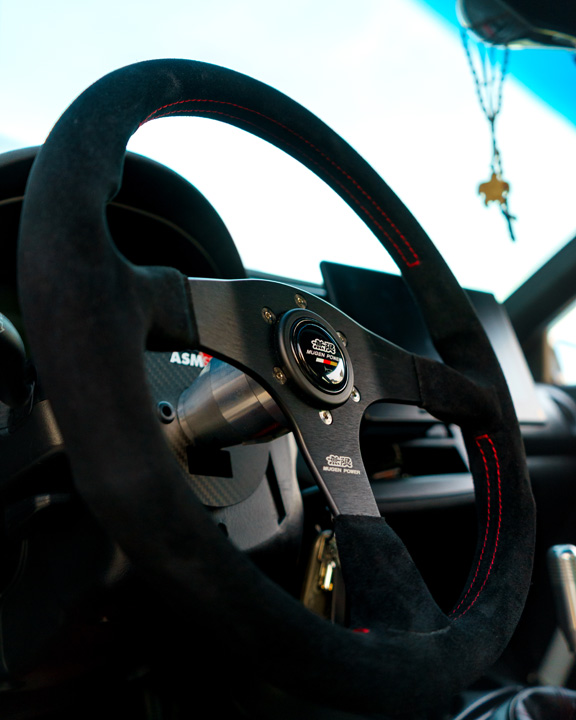 Jonathan Ortiz’s 2005 Acura RSX Type-S with Porsche PTS Fashion Grey paint, Mugen aero, J’s Racing details, blue Volk Racing CE28N wheels, turbocharged K-series engine bay, DC5R interior conversion, and Sony ES audio setup.
