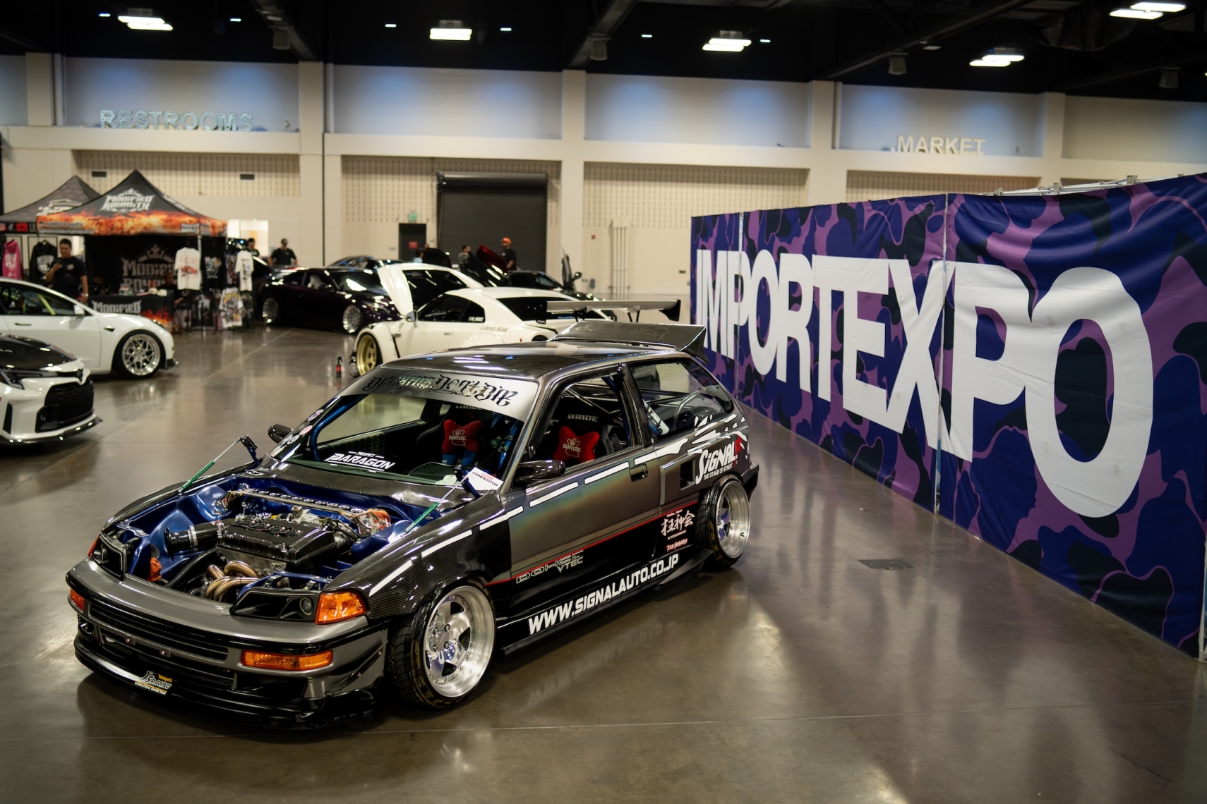 Modified Honda Civic displayed beside IMPORTEXPO signage during IMPORTEXPO Texas 2026 in the Austin area.