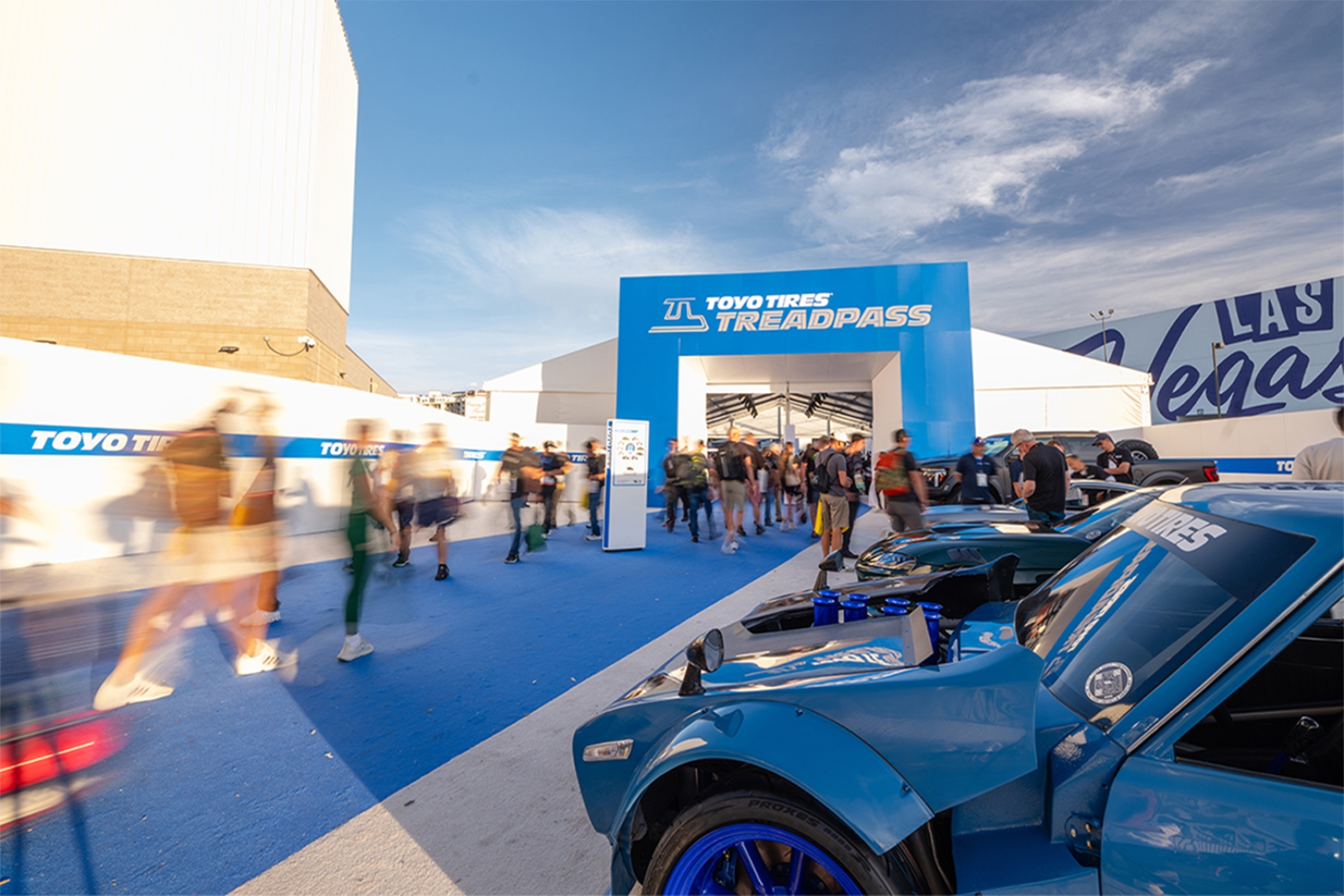 Toyo Tires Treadpass showcase at the SEMA Show in Las Vegas, featuring custom vehicles, attendees and the signature blue Treadpass entrance.