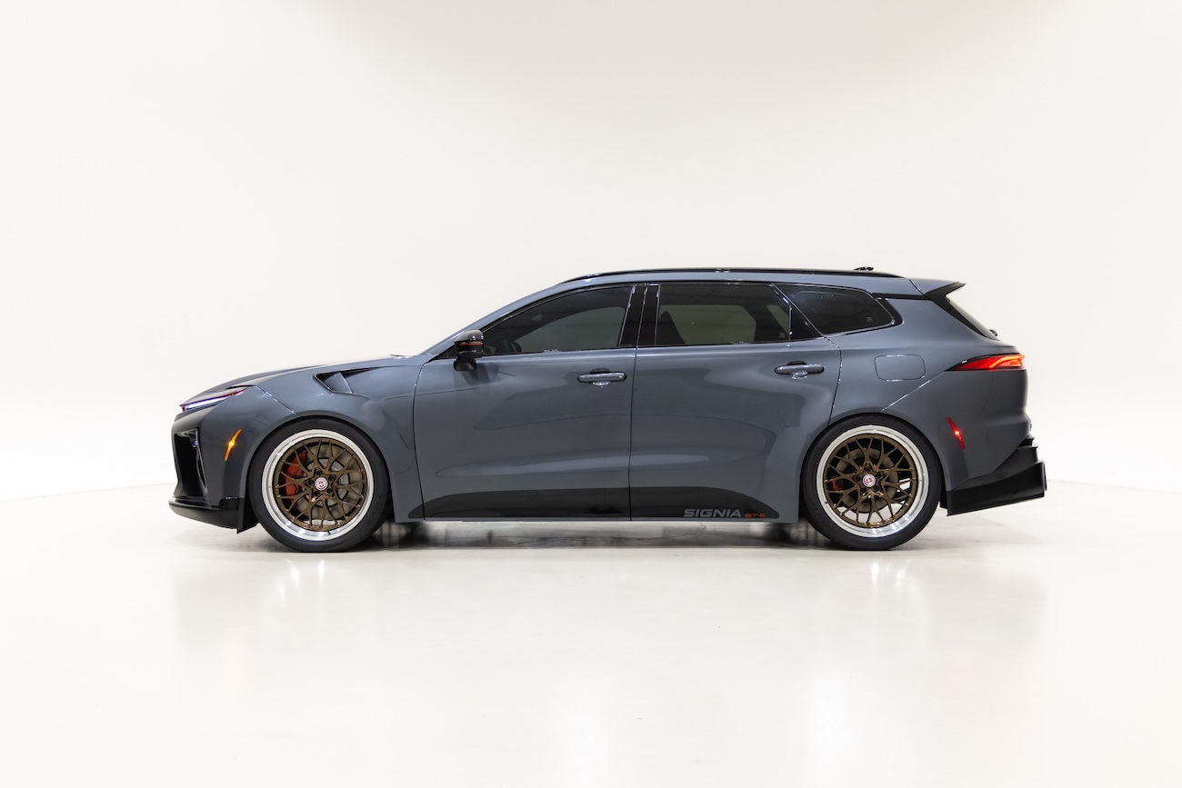 Side profile of the Toyota Crown Signia GT-S Concept featuring dark gray metallic paint, custom widebody styling, lowered suspension, bronze 21-inch HRE wheels and rear aerodynamic enhancements.
